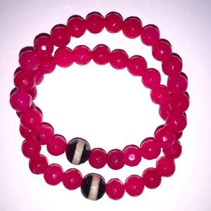 Pair of bright pink agate bead stretch bracelets with dzi bead accent